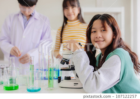 Portrait smart young asian teen girl enjoy learning and play in school experimental chemical science lab  happy smiling 107122257