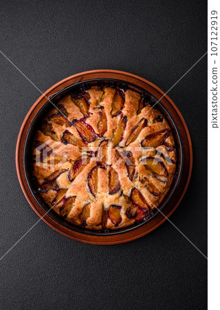Delicious sweet aromatic homemade pie with ripe plums 107122919
