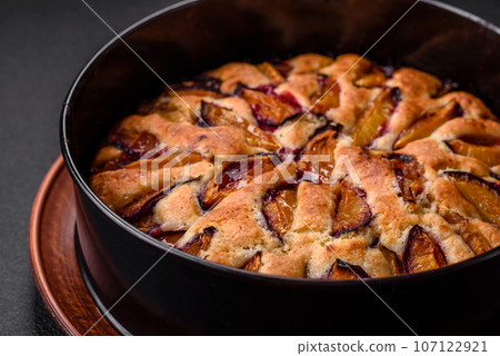 Delicious sweet aromatic homemade pie with ripe plums Delicious sweet aromatic homemade pie with ripe plums 107122921