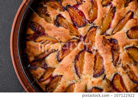 Delicious sweet aromatic homemade pie with ripe plums Delicious sweet aromatic homemade pie with ripe plums 107122922