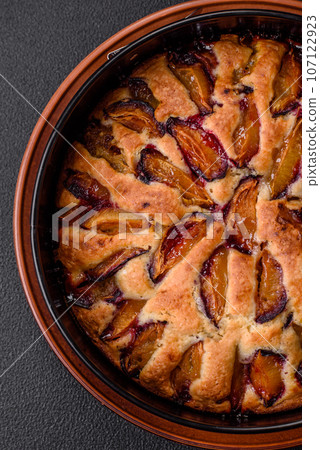 Delicious sweet aromatic homemade pie with ripe plums 107122923