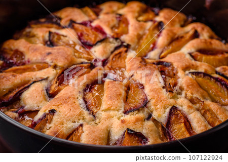 Delicious sweet aromatic homemade pie with ripe plums Delicious sweet aromatic homemade pie with ripe plums 107122924