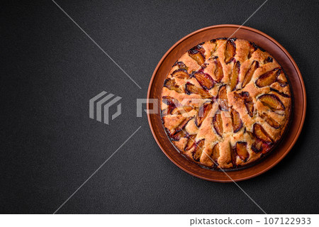 Delicious sweet aromatic homemade pie with ripe plums Delicious sweet aromatic homemade pie with ripe plums 107122933