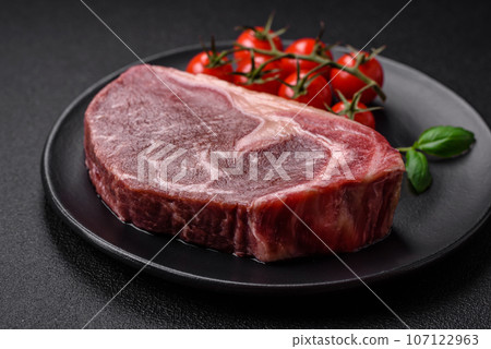 Fresh raw beef striploin steak with salt, spices and herbs Fresh raw beef striploin steak with salt, spices and herbs 107122963