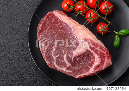Fresh raw beef striploin steak with salt, spices and herbs Fresh raw beef striploin steak with salt, spices and herbs 107122964