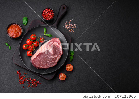 Fresh raw beef striploin steak with salt, spices and herbs 107122969