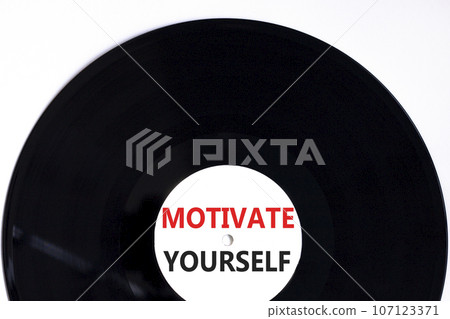 Motivate yourself symbol. Concept words Motivate yourself on beautiful black vinyl disk. Beautiful white table white background. Business psychology motivate yourself concept. Copy space. 107123371