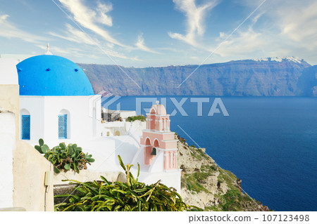 White architecture on Santorini island, Greece. Beautiful landscape with caldera sea view and cloudy sky. White architecture on Santorini island, Greece. Beautiful landscape with caldera sea view and cloudy sky. 107123498