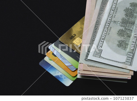 bank plastic credit cards and debit cards and us dollars on a black background 107123837