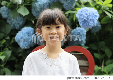 Elementary school girl (8 years old) and hydrangea (blue) Elementary school girl (8 years old) and hydrangea (blue) 107124003
