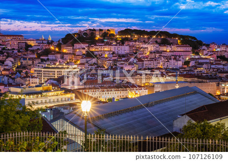 View of Lisbon famous view from Miradouro de Sao Pedro de Alcantara tourist viewpoint in the evening. Lisbon, Portugal. Camera pan 107126109