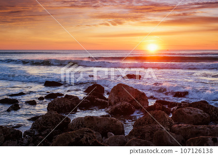 Atlantic ocean sunset with waves and rocks at Costa da Caparica, Portugal 107126138