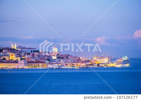 View of Lisbon over Tagus river with moored cruise liner in evening twilight. Lisbon, Portugal 107126177