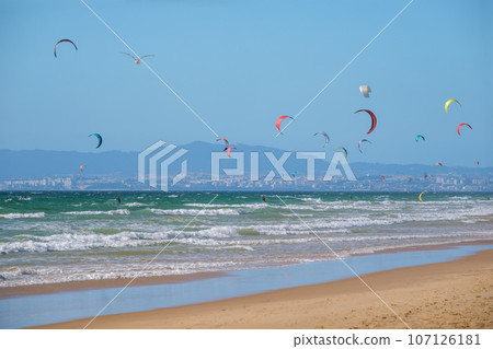 Kiteboarding kitesurfing kiteboarder kitesurfer kites on the Atlantic ocean beach at Fonte da Telha beach, Costa da Caparica, Portugal 107126181