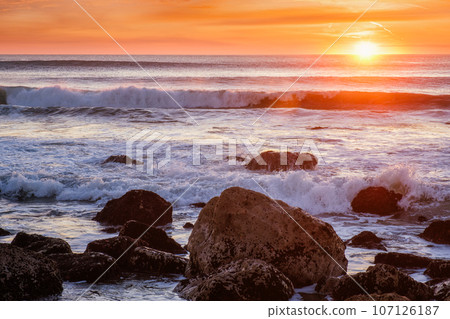 Atlantic ocean sunset with waves and rocks at Costa da Caparica, Portugal 107126187