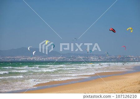 Kiteboarding kitesurfing kiteboarder kitesurfer kites on the Atlantic ocean beach at Fonte da Telha beach, Costa da Caparica, Portugal Kiteboarding kitesurfing kiteboarder kitesurfer kites on the Atlantic ocean beach at Fonte da Telha beach, Costa da Caparica, Portugal 107126210