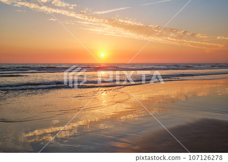 Atlantic ocean sunset with surging waves at Fonte da Telha beach, Costa da Caparica, Portugal 107126278