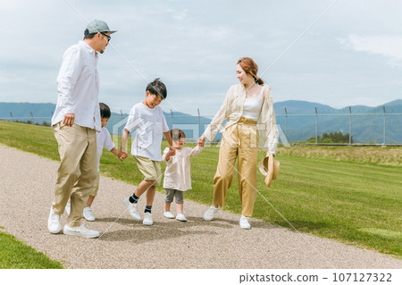A family walking in a park with a view of the blue sky (family of 5) 107127322