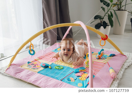 cute baby playing with toys indoors on the floor. High quality photo 107127739