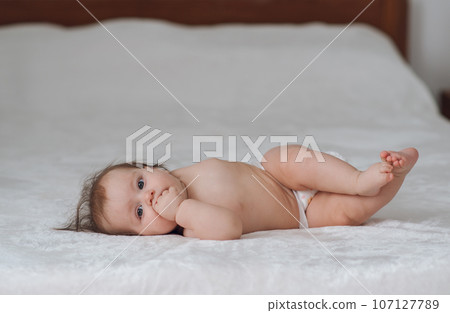 Portrait of a happy cute baby on a white bed. High quality photo Portrait of a happy cute baby on a white bed. High quality photo 107127789