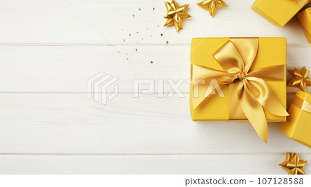 yellow gift box on white wooden background with space for text. High quality photo 107128588