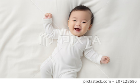 Healthy cheerful asian toddler lying on white blanket. High quality photo Healthy cheerful asian toddler lying on white blanket. High quality photo 107128686