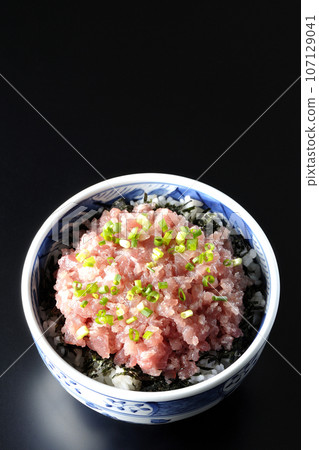 黑色背景下鮪魚塔塔基碗的頭頂照片，上面有很多蔥 107129041