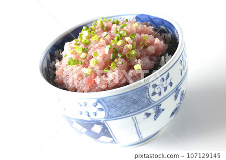 A photo of a tuna tataki bowl topped with lots of green onions against a white background 107129145