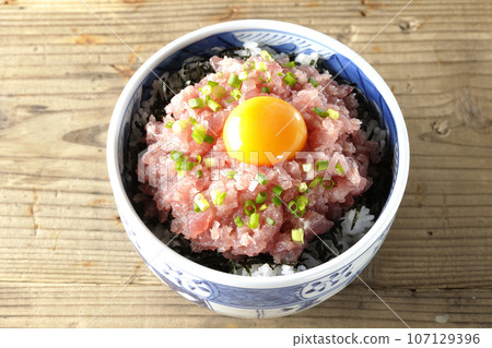 An overhead shot of the tuna tataki bowl topped with green onion and egg yolk 107129396