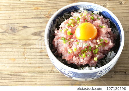 An overhead shot of the tuna tataki bowl topped with green onion and egg yolk 107129398