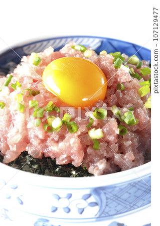 白色背景下拍攝的鮪魚塔塔基碗，上面放著蔥和蛋黃 107129477