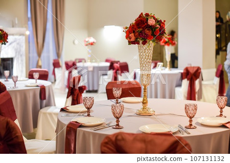 Festive setting of tables for an event, tablecloth, dishes, bouquets Festive setting of tables for an event, tablecloth, dishes, bouquets 107131132