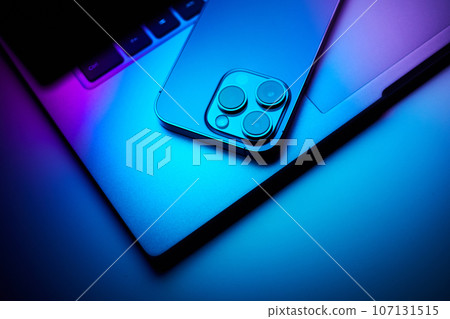 Laptop with smartphone. Neon dark light. 107131515