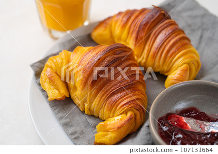 Brioche croissants on a plate with a small bowl of jam Brioche croissants on a plate with a small bowl of jam 107131664