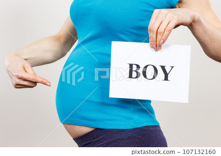 Pregnant woman holding card with inscription boy. Expecting for newborn. Extending family Pregnant woman holding card with inscription boy. Expecting for newborn. Extending family 107132160