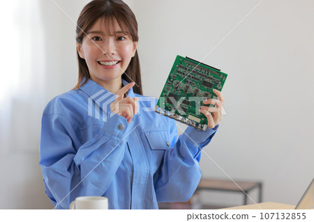 Woman in work clothes pointing at the board 1 107132855