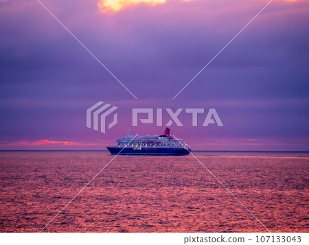 A luxury cruise ship departing from Kutsugata Port on Rishiri Island in the Sea of Japan off the coast of Wakkanai City, Hokkaido, and sailing on the sea off the coast of Cape Kutsugata, which glows red at sunset. A luxury cruise ship departing from Kutsugata Port on Rishiri Island in the Sea of Japan off the coast of Wakkanai City, Hokkaido, and sailing on the sea off the coast of Cape Kutsugata, which glows red at sunset. 107133043