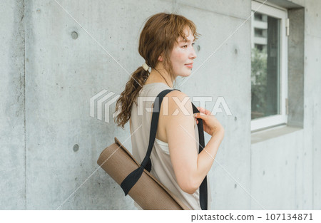 A woman who is a yoga instructor with a yoga mat, a woman who does yoga and Pilates A woman who is a yoga instructor with a yoga mat, a woman who does yoga and Pilates 107134871