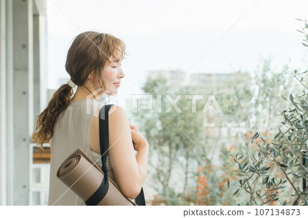 A woman who is a yoga instructor with a yoga mat, a woman who does yoga and Pilates A woman who is a yoga instructor with a yoga mat, a woman who does yoga and Pilates 107134873