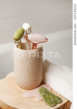 Jade face rollers for beauty facial massage therapy with towel on the wood in bathroom Jade face rollers for beauty facial massage therapy with towel on the wood in bathroom 107138222