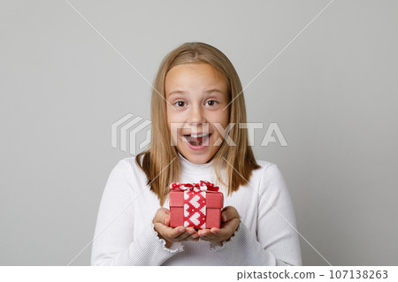 Portrait of happy surprised little child girl holding gift present box  107138263