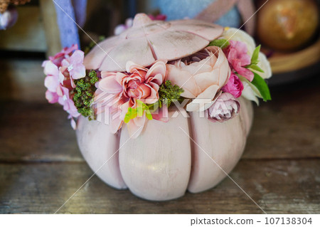 Beautiful composition of flowers in the pink pumpkin on wood table Beautiful composition of flowers in the pink pumpkin on wood table 107138304