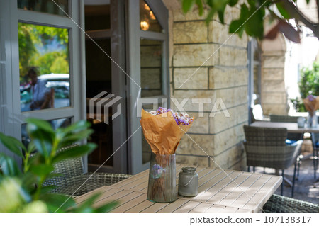 Cozy outdoor cafe with dried flowers on the table 107138317