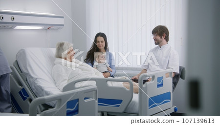 Doctor uses digital tablet, consults female senior patient 107139613