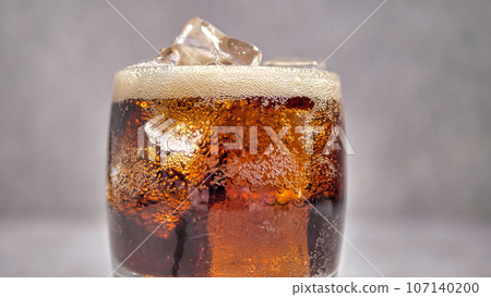 soda in a glass with ice, close-up 107140200