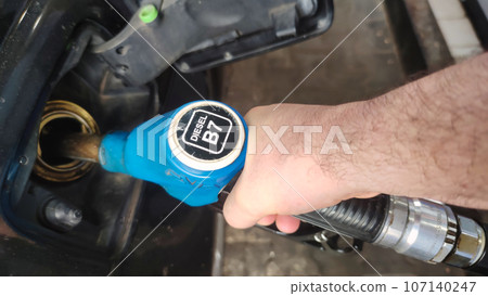 Manually refueling the car with fuel at the gas station 107140247