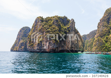A picturesque beautiful place on the island of Phi Phi Leh - Pi Leh Lagoon is popular for excursions with tourists on traditional Thai fishing boats. Island travel in Thailand. A picturesque beautiful place on the island of Phi Phi Leh - Pi Leh Lagoon is popular for excursions with tourists on traditional Thai fishing boats. Island travel in Thailand. 107140428