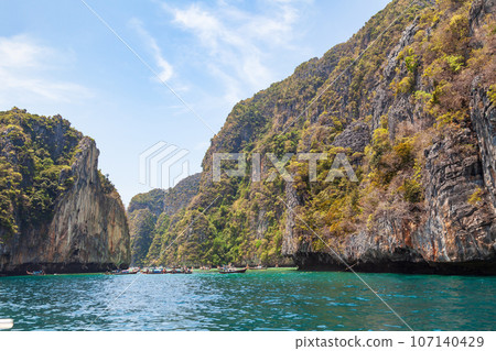 A picturesque beautiful place on the island of Phi Phi Leh - Pi Leh Lagoon is popular for excursions with tourists on traditional Thai fishing boats. Island travel in Thailand. A picturesque beautiful place on the island of Phi Phi Leh - Pi Leh Lagoon is popular for excursions with tourists on traditional Thai fishing boats. Island travel in Thailand. 107140429