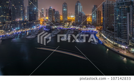 Luxury yacht bay in the city aerial all night in Dubai marina Luxury yacht bay in the city aerial all night in Dubai marina 107142833
