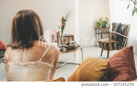 一個女人坐在客廳放鬆 一個女人坐在客廳放鬆 107145259